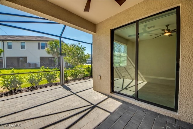 unfurnished sunroom featuring a ceiling fan