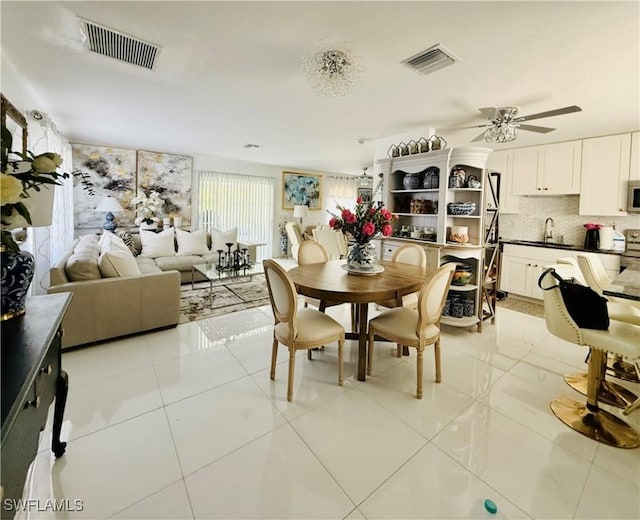 dining space with a ceiling fan, visible vents, and light tile patterned floors
