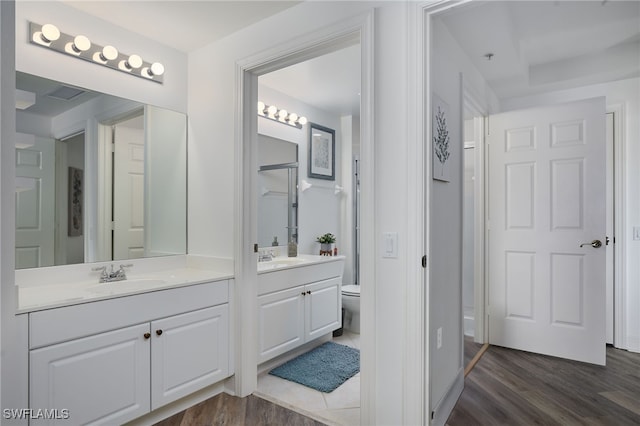 2743 1st St Unit 2001, Fort Myers, FL 33916 - bathroom featuring toilet, two vanities, a sink, and wood finished floors
