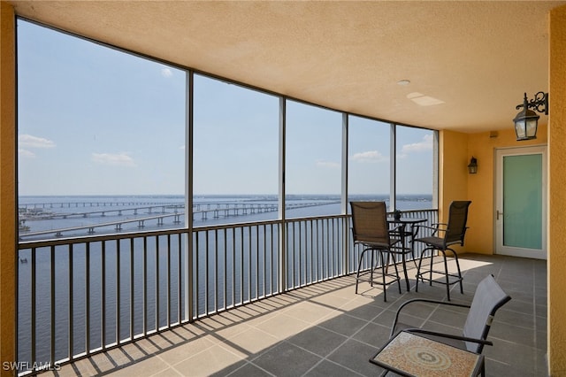 2743 1st St Unit 2001, Fort Myers, FL 33916 - sunroom / solarium featuring expansive windows, a textured ceiling, a water view, and tile patterned floors