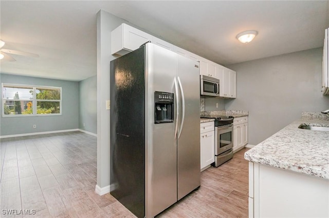 kitchen featuring appliances with stainless steel finishes, light wood-style flooring, a ceiling fan, and white cabinetry