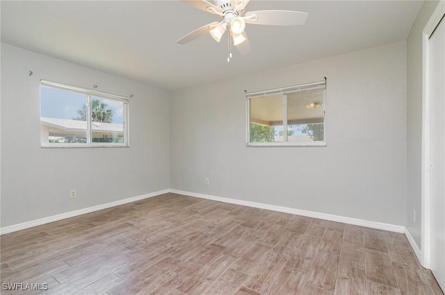 unfurnished room with a ceiling fan, light wood finished floors, and plenty of natural light