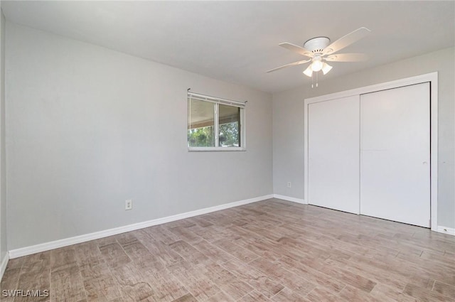 unfurnished bedroom with baseboards, light wood finished floors, a closet, and a ceiling fan