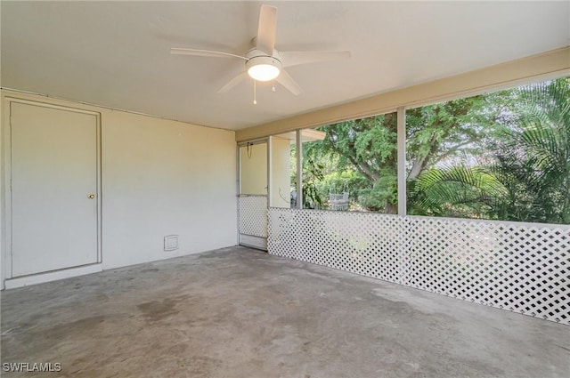 unfurnished sunroom featuring ceiling fan