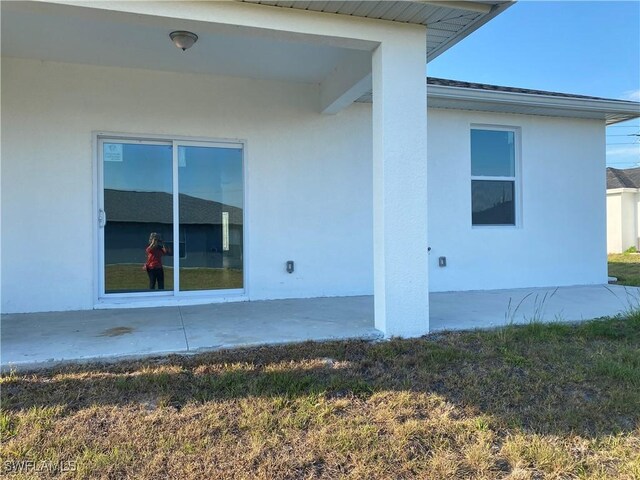 5249-5251 Centennial Blvd, Lehigh Acres, FL 33971 - view of side of home featuring stucco siding and a patio