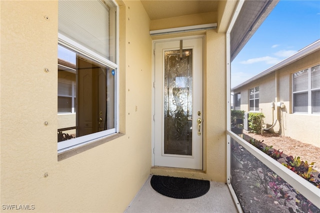 doorway to property with stucco siding and a balcony