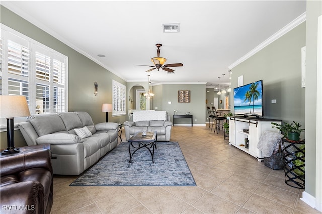 living room with a healthy amount of sunlight, ceiling fan with notable chandelier, light tile patterned flooring, and visible vents