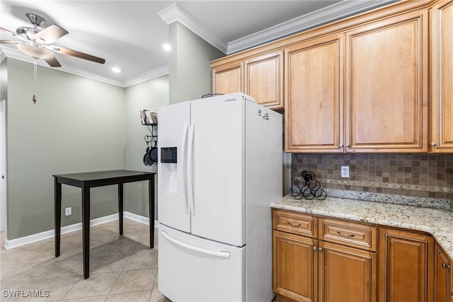 kitchen with crown molding, ceiling fan, white fridge with ice dispenser, light tile patterned floors, and tasteful backsplash
