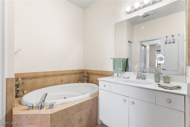 bathroom with a tub with jets and vanity