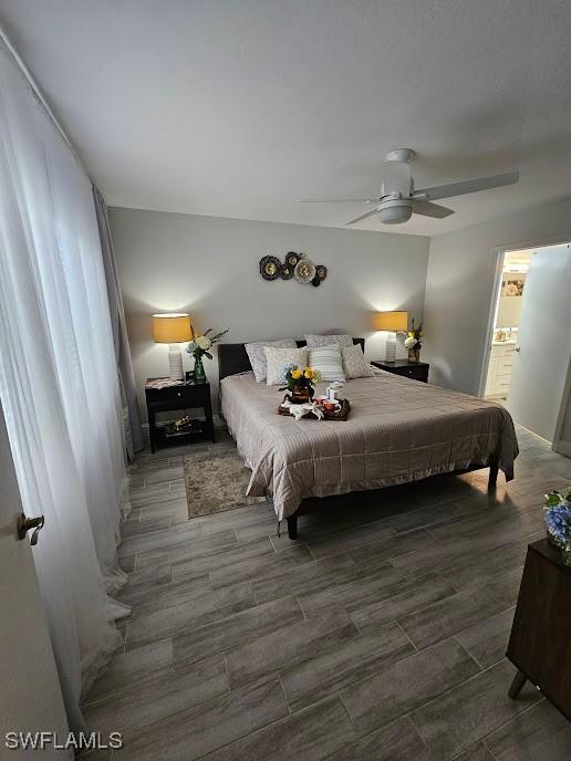 bedroom with ensuite bathroom, a ceiling fan, and wood finish floors