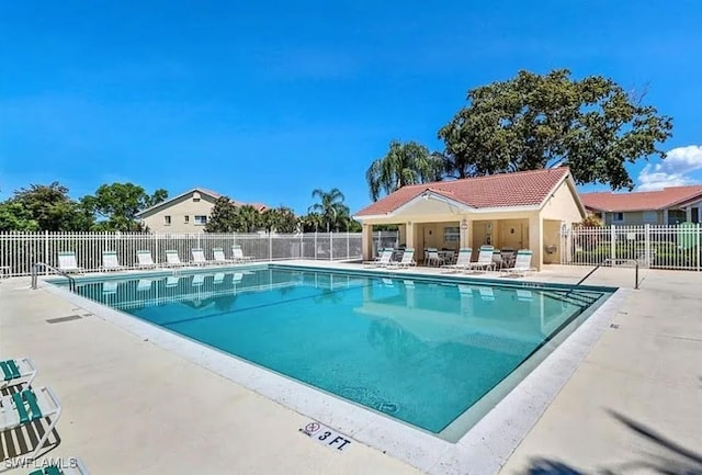 community pool with fence and a patio