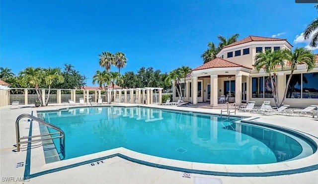 community pool with a patio and fence