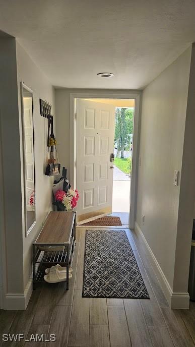 entryway with baseboards and wood finished floors