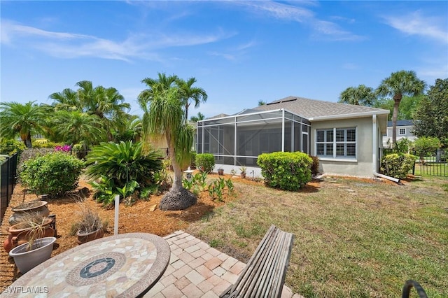 23125 Marsh Landing Blvd, Estero, FL 33928 - back of house featuring a lawn, fence, glass enclosure, and stucco siding