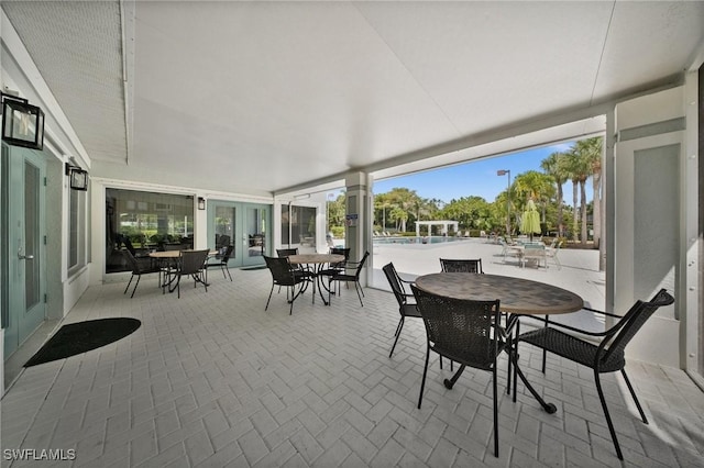23125 Marsh Landing Blvd, Estero, FL 33928 - view of patio featuring outdoor dining area, a community pool, and french doors
