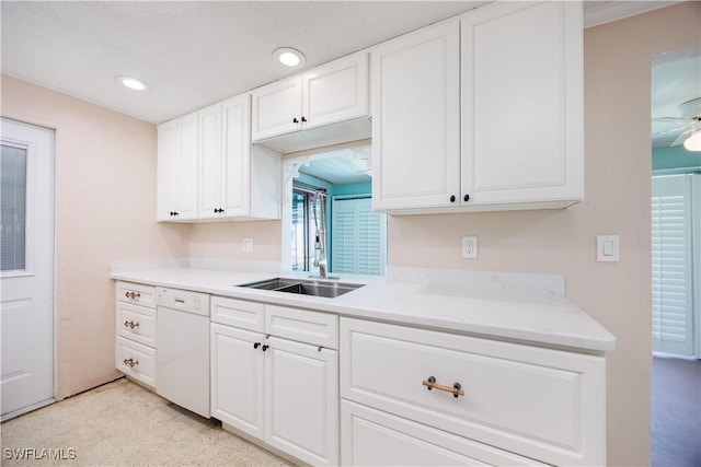 kitchen featuring a ceiling fan, white dishwasher, a sink, white cabinets, and recessed lighting