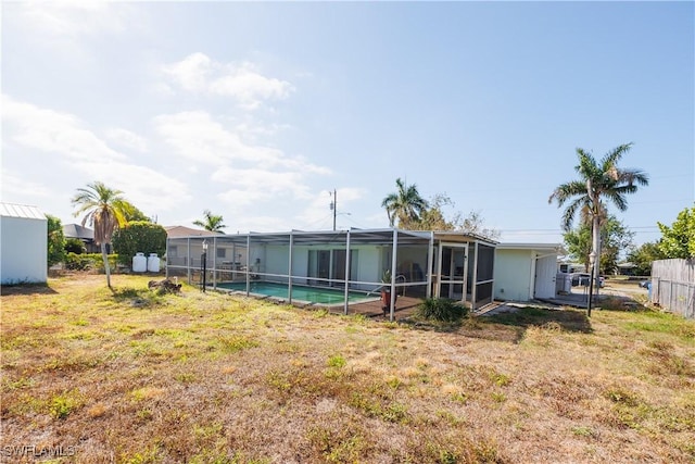 view of yard with fence, a fenced in pool, and glass enclosure