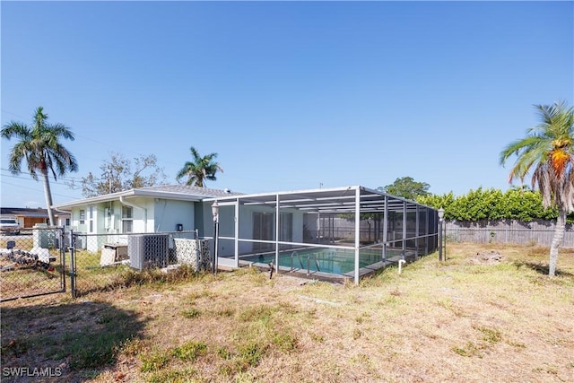 exterior space featuring a fenced backyard, a fenced in pool, central AC unit, a lanai, and a yard