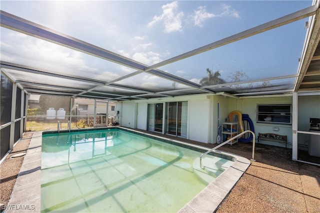 outdoor pool with glass enclosure and a patio area