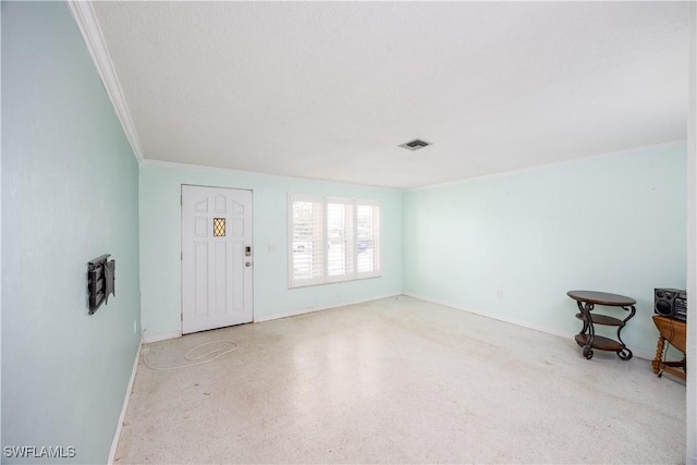 foyer with crown molding, baseboards, speckled floor, and visible vents