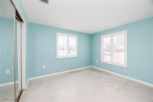 unfurnished bedroom with a closet, baseboards, and visible vents