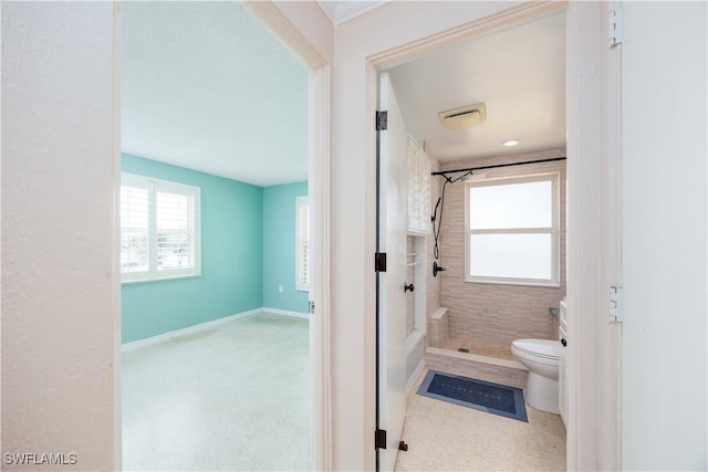 bathroom featuring baseboards, a wealth of natural light, toilet, and a shower stall