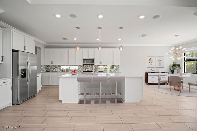 kitchen with backsplash, white cabinets, appliances with stainless steel finishes, and light countertops