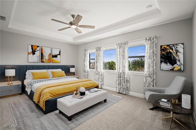carpeted bedroom with crown molding, ceiling fan, baseboards, a tray ceiling, and visible vents