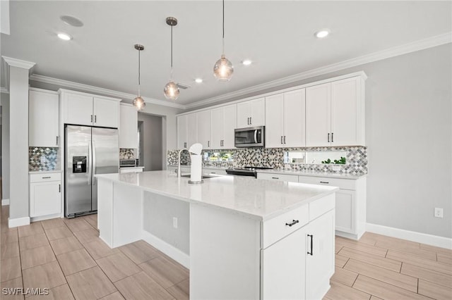 kitchen featuring ornamental molding, a center island with sink, tasteful backsplash, a sink, and appliances with stainless steel finishes