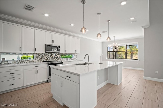 kitchen featuring visible vents, tasteful backsplash, a sink, baseboards, and stainless steel appliances