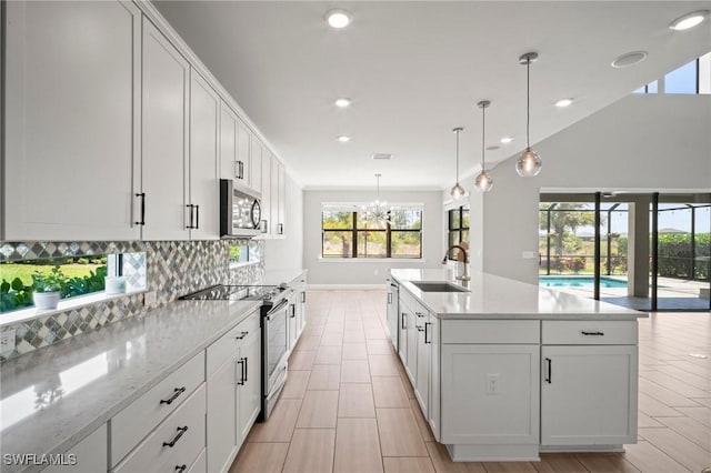 kitchen with recessed lighting, white cabinetry, tasteful backsplash, a sink, and appliances with stainless steel finishes