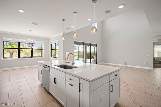 kitchen featuring visible vents, dishwasher, a sink, baseboards, and open floor plan