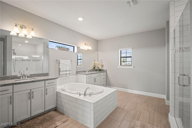 full bathroom with a sink, a bath, two vanities, and a shower stall