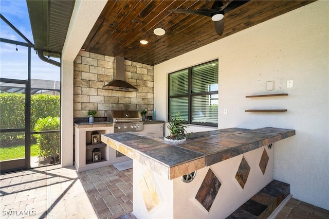 view of patio / terrace featuring grilling area, a ceiling fan, a lanai, and exterior kitchen