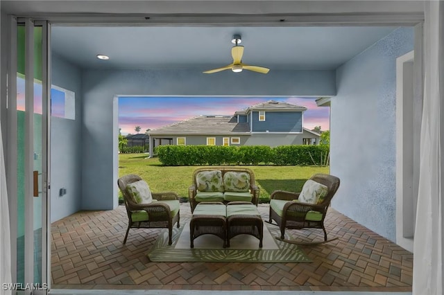 3419 Pilot Cir, Naples, FL 34120 - patio terrace at dusk featuring an outdoor living space, ceiling fan, and a yard