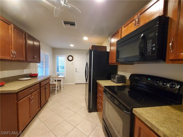 8657 Querce Ct, Naples, FL 34114 - kitchen featuring black appliances, light tile patterned floors, brown cabinetry, a ceiling fan, and light countertops