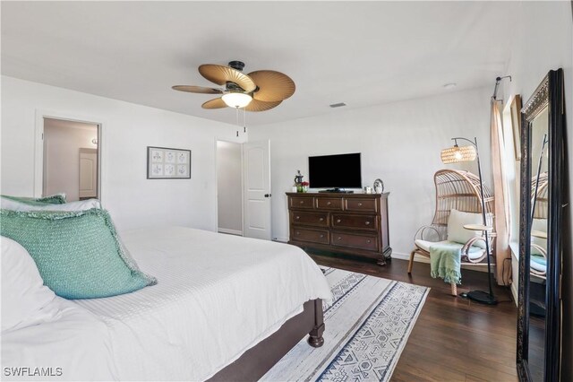 bedroom featuring a ceiling fan, visible vents, and dark wood-type flooring