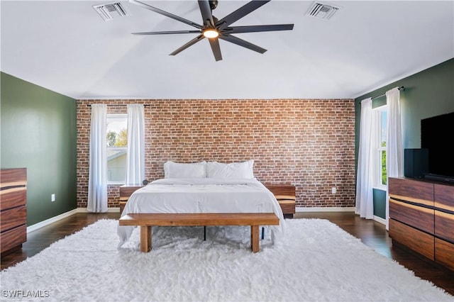 bedroom with visible vents, brick wall, vaulted ceiling, and baseboards