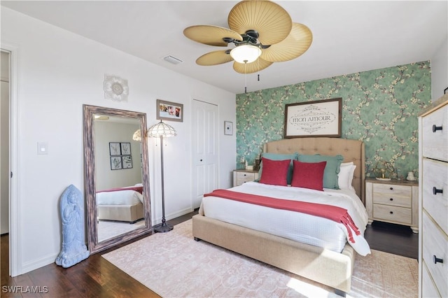 bedroom with visible vents, ceiling fan, wallpapered walls, baseboards, and wood finished floors