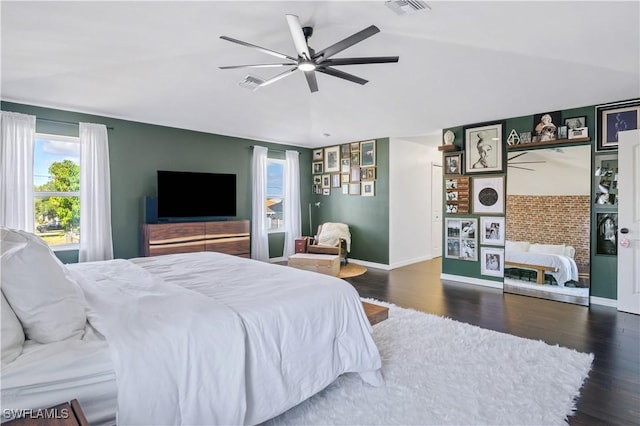 bedroom with visible vents, vaulted ceiling, wood finished floors, and baseboards