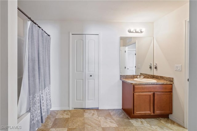 bathroom featuring curtained shower, vanity, and baseboards
