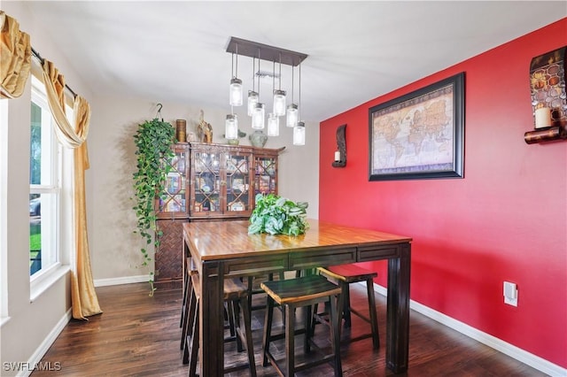 dining space with wood finished floors and baseboards