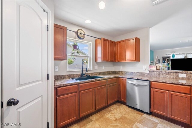 kitchen with stainless steel dishwasher, recessed lighting, a sink, and brown cabinets