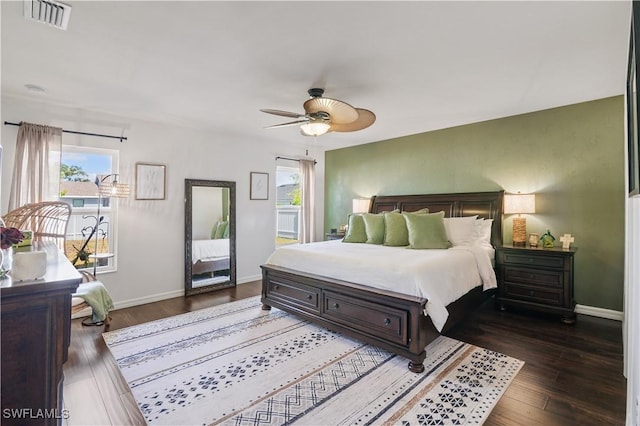 bedroom with wood finished floors, visible vents, and multiple windows