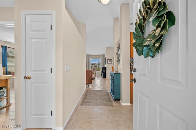 foyer entrance with light tile patterned floors and baseboards