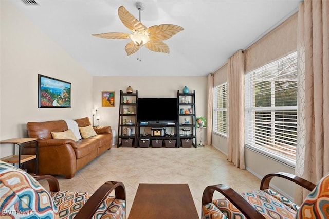 living area with light tile patterned floors, a ceiling fan, and vaulted ceiling