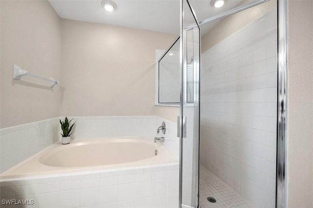bathroom featuring a bath and a stall shower