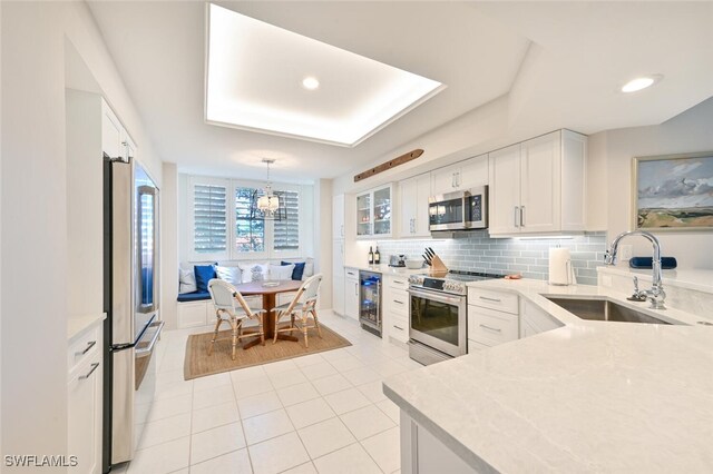 6549 Marissa Loop Unit 26, Naples, FL 34108 - kitchen with light tile patterned flooring, a sink, stainless steel appliances, tasteful backsplash, and wine cooler