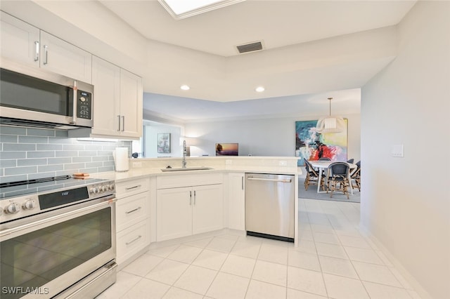 6549 Marissa Loop Unit 26, Naples, FL 34108 - kitchen featuring a sink, light countertops, a peninsula, stainless steel appliances, and white cabinetry