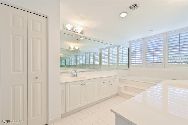 6549 Marissa Loop Unit 26, Naples, FL 34108 - bathroom featuring vanity, visible vents, a bath, and a closet